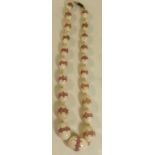 An early 20th Century stained ivory bead necklace Having twenty one oval shaped beads,