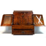 A late 19th/early 20th century oak desk top stationary cabinet The twin angled doors enclosing