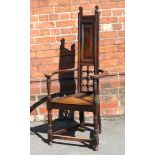 An Arts & Crafts oak hall chair Possibly Scottish, having carved bent side arms,