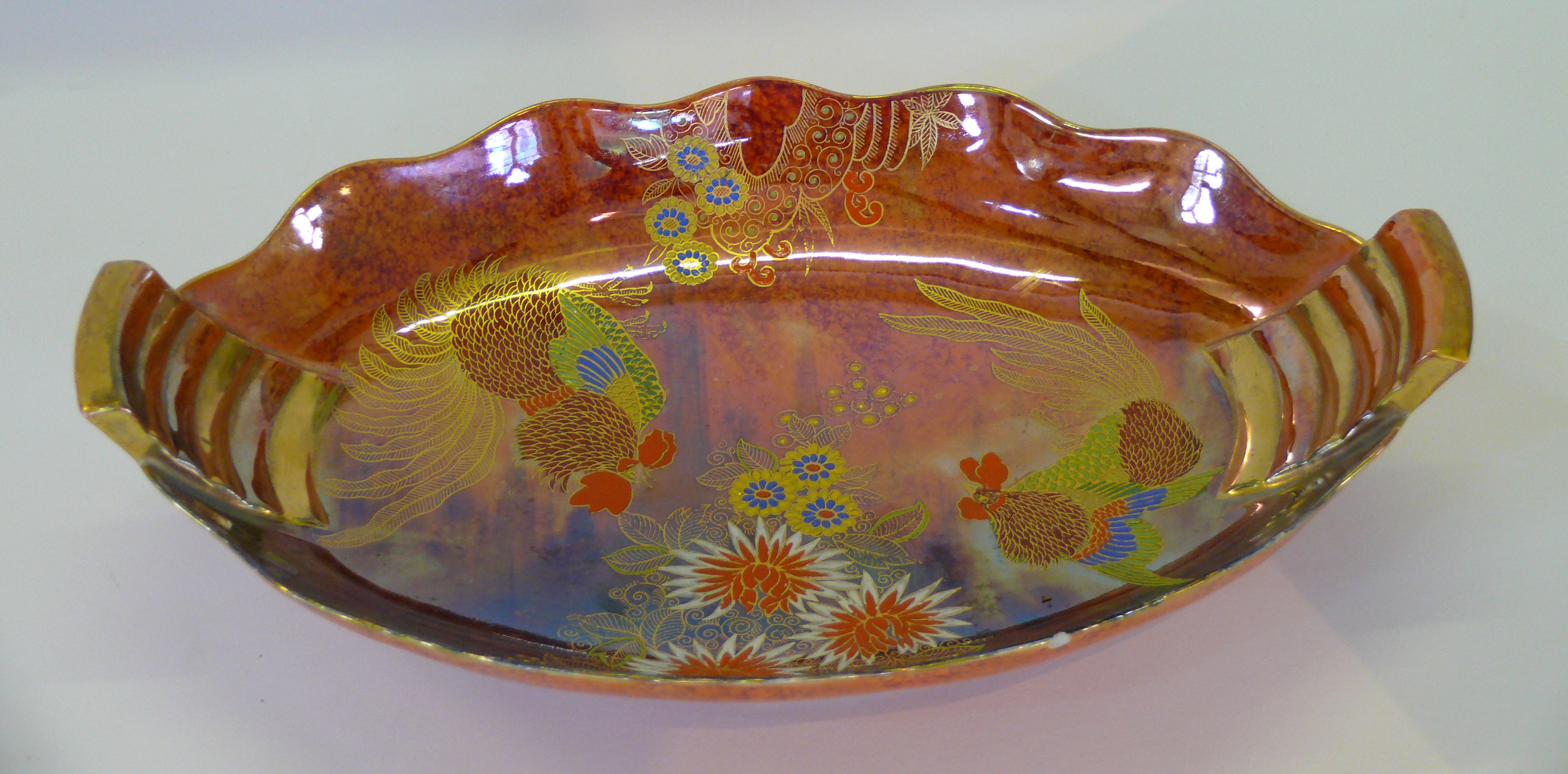 An Art Deco Carlton Ware twin handled lustre bowl 'Fighting Cocks' pattern on an orange lustre