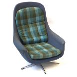 A contemporary reclining armchair Circa 1960s, upholstered in a green and blue checkered material,