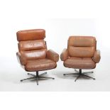 A Guy Rogers 1960's tan leather swivel armchair The concave teak back with two fitted cushions