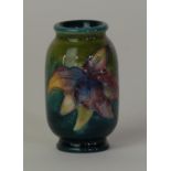 A Walter Moorcroft miniature vase of cylindrical form Decorated in the 'Orchid' pattern on a green