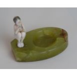 An Art Deco ivorine figure group Depicting a snake charmer, raised on an onyx plinth base,