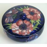 A Walter Moorcroft pottery circular trinket bowl and cover Decorated in the Anemone pattern on a