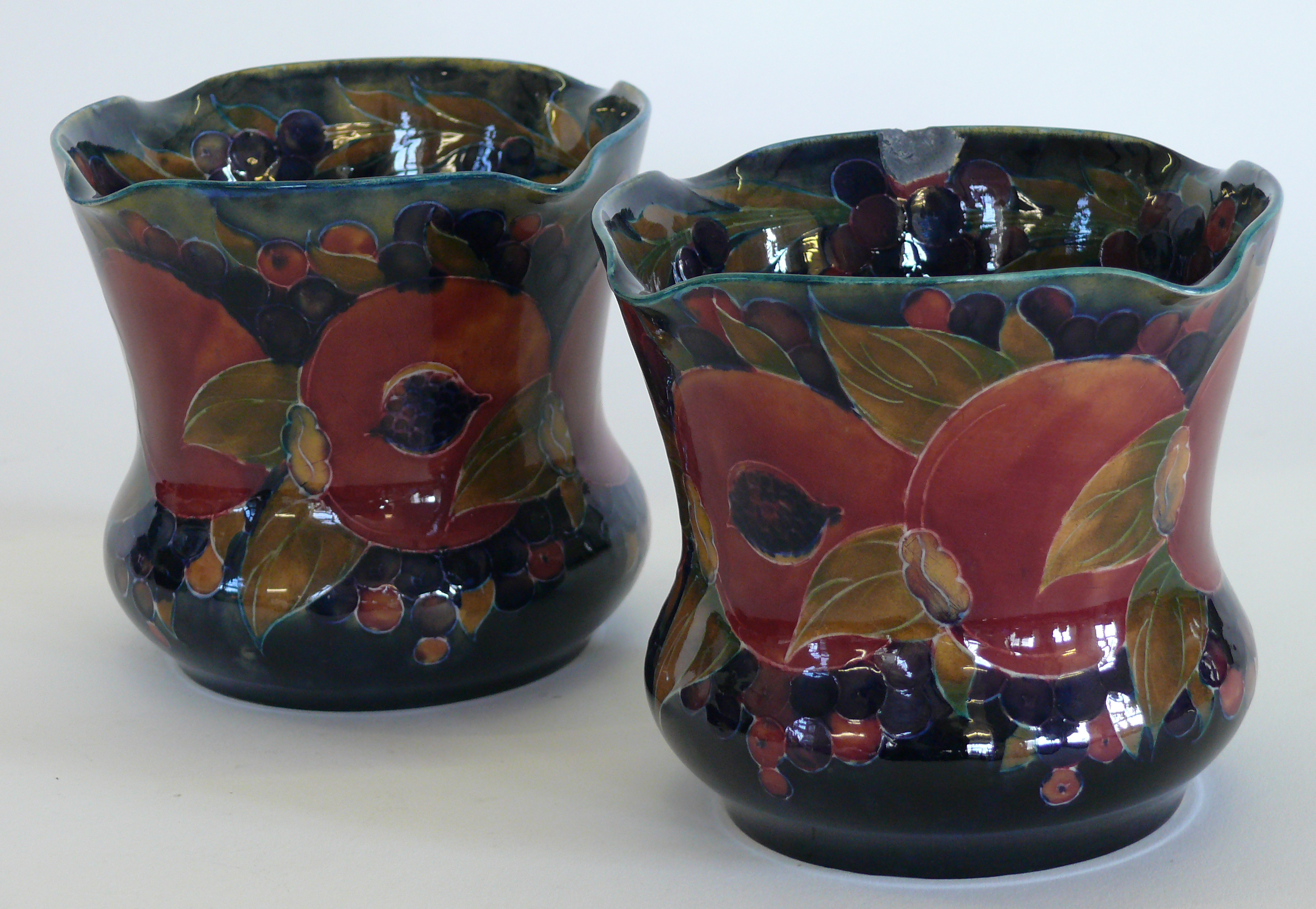 A pair of William Moorcroft pottery jardineres of square form Decorated in the Pomegranate pattern