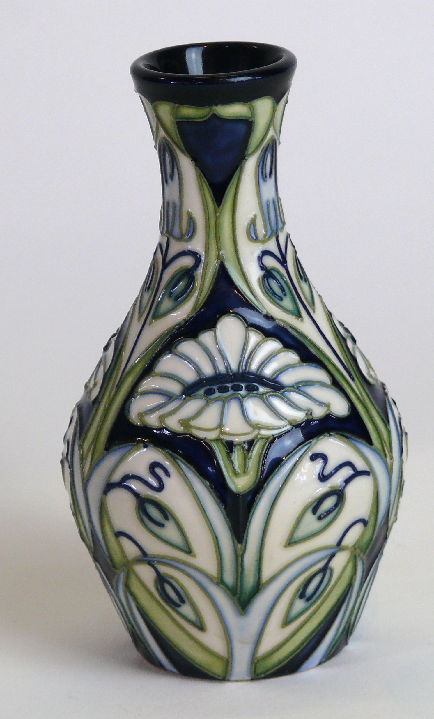 A modern Moorcroft pottery vase of baluster form Decorated with stylised flower heads on an ivory