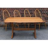 An Ercol light elm five piece dining suite Comprising refectory table,