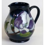 A modern Moorcroft jug of baluster form Decorated in the Magnolia pattern on a blue ground,