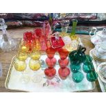 A collection of coloured glass items including a Mary Gregory style cranberry glass vase,