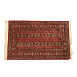 A Bokhara style rug Of rectangular form with tasselled edging,