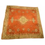 A large Persian Bokhara style rug The vibrant orange ground rug, of rectangular form,