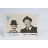 A Laurel and Hardy autographed photograph postcard Signed 'To Gussy'.