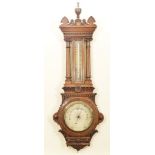 A late Victorian oak cased wall barometer The centered silvered dial with glazed mercury