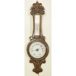 An early 20th Century oak cased aneroid barometer The white enamelled dial below mercury
