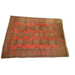 A large Persian Bokhara style rug The vibrant red madder round rug, of rectangular form,