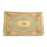 A Chinese green ground rug Of rectangular form with tasselled edging,