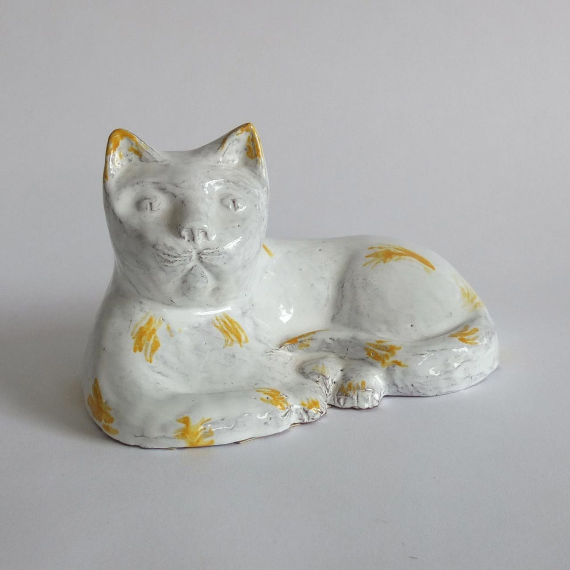 FELDMANN, Emmi (*07.02.1918 +17.04.2015 Münster), Ton, liegende Katze, weiß glasiert, gelb