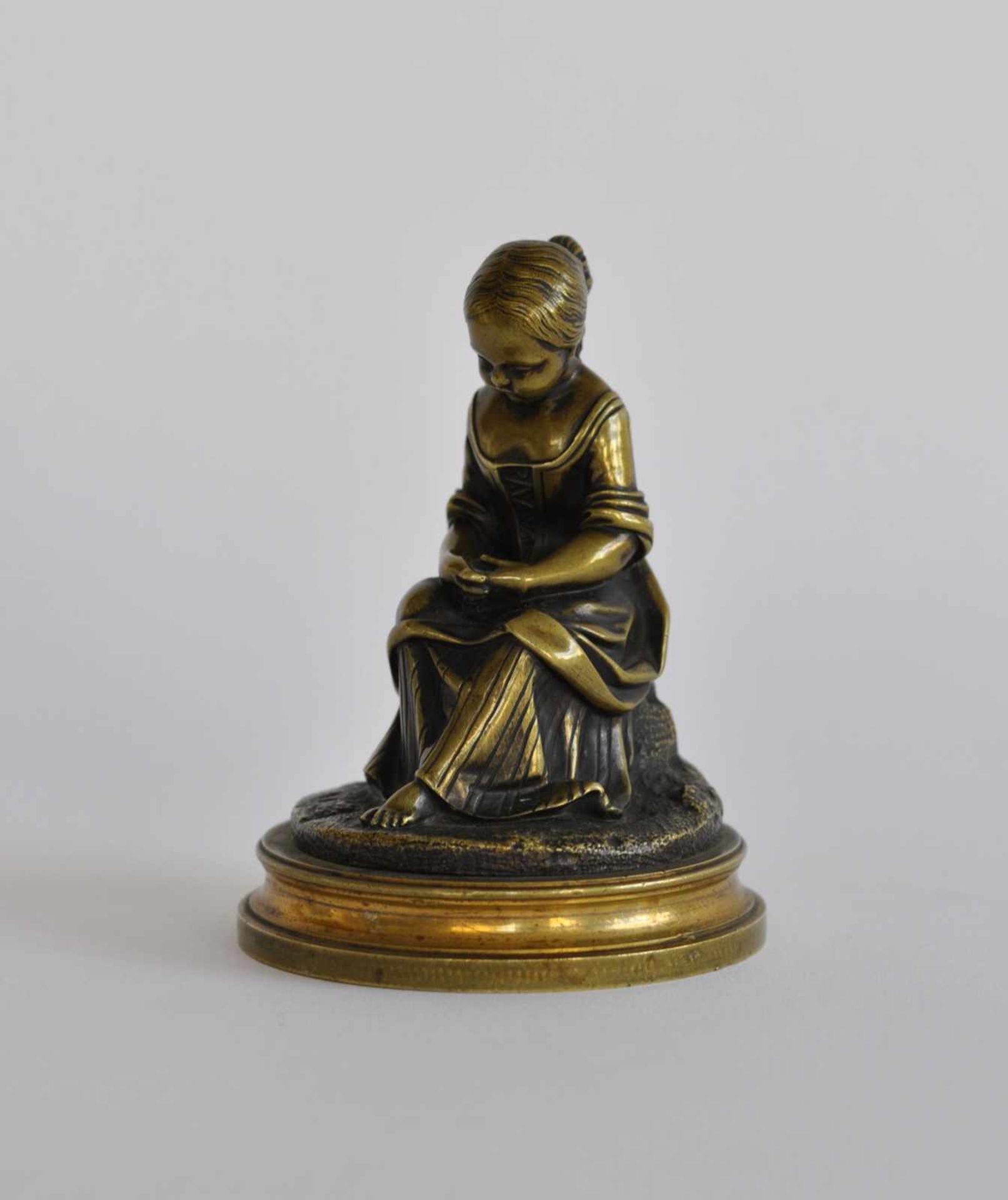SKULPTUR, 19.Jh., Wiener Bronze, patiniert, junge Magd auf Stein sitzend, Natursockel und runde