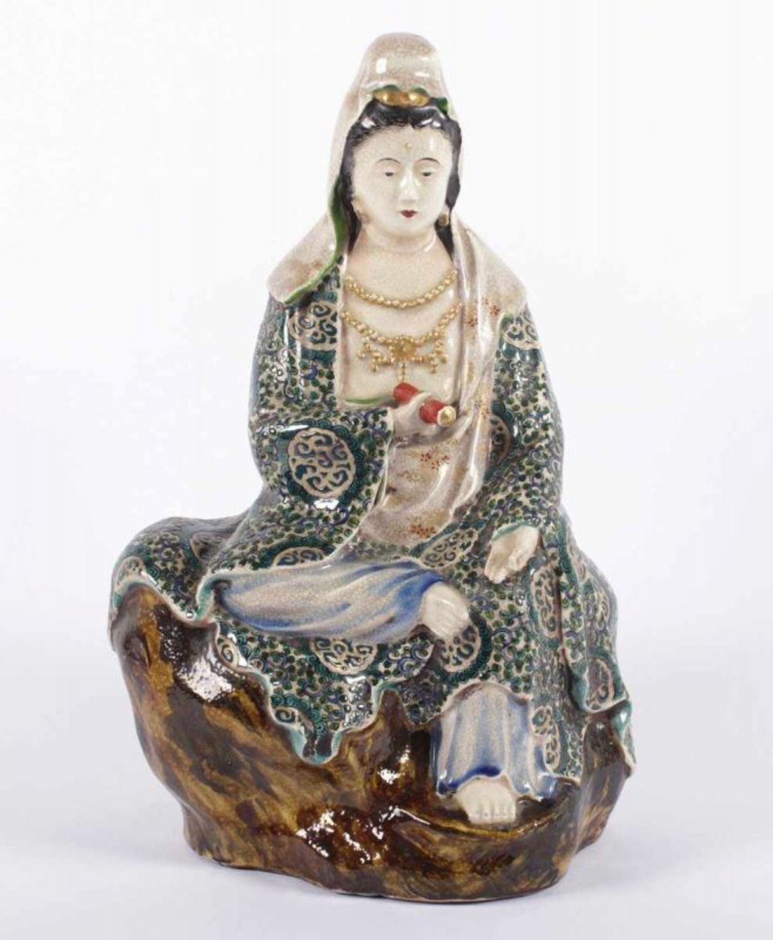 SATSUMA-KANNON, in polychromen Farben und Gold dekoriert, auf einem Fels sitzende Darstellung, H 30,