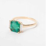 An 18 carat gold ring with emerald and diamonds 20th century The gold ring set with a central