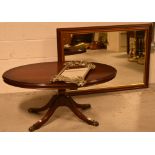 A reproduction mahogany oval coffee table, raised on quadripartite base to hairy paw feet,