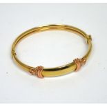 A yellow and rose gold bangle, unmarked, approx 9.6g.