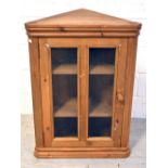 A single-door pine corner cabinet with integral shelving, width 64cm.