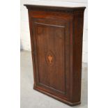 A 19th century oak corner cupboard with central marquetry cartouche of urn and swag with mahogany