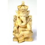 A late 19th century carved ivory depiction of the Hindu god Ganesh seated on a double lotus form