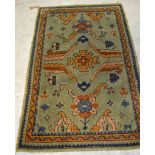 An Eastern green ground rug with floral design, 140 x 84cm.