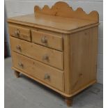 A 20th century pine two-over-two chest of drawers with upper carved pediment, width 110cm.