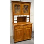 A 20th century pine dresser, two astragal glazed doors above named ceramic drawers,