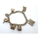 A hallmarked silver charm bracelet set with various charms to include a pram, bus and a bible,