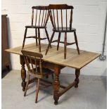 A 20th century oak extending dining table on baluster supports with conjoining stretcher,