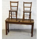 A vintage child's double school desk, width 102cm and a pair of matching ladder back chairs (3).