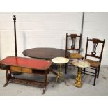 A reproduction mahogany oval table raised on quadripartite base to brass caps and castors,