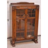 A 20th century freestanding oak bookcase/display cabinet with twin astragal glazed doors,