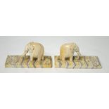 A pair of 19th century carved ivory elephants, each raised on mammoth teeth bases,