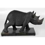 A decorative carved wooden model of a rhinoceros, on a rectangular plinth base, length 37cm.