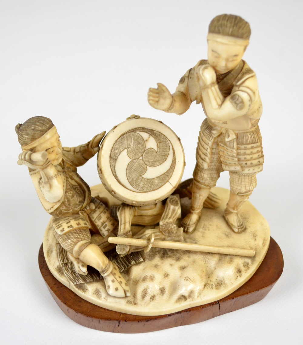 Japanese Meiji period carved ivory sectional okimono figure group of a man playing a drum and a