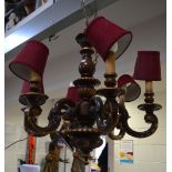 A six-branch wooden candelabrum with burgundy silk shades, height 65cm.