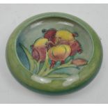 A Moorcroft circular bowl with inverted rim, tube-line decorated over a green ground,