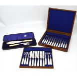 An oak-cased set of silver plated knives and forks with mother of pearl handles housed within two