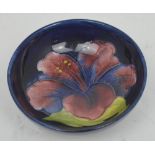 A Moorcroft circular footed bowl, tube-line decorated with hibiscus over a cobalt blue ground,