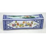 A Chinese porcelain headrest with hand painted decoration of costumed children playing boardgames