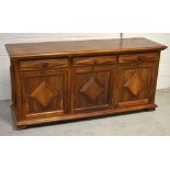 A South American hardwood three-drawer sideboard with stylised raised panel decoration, width 165cm.