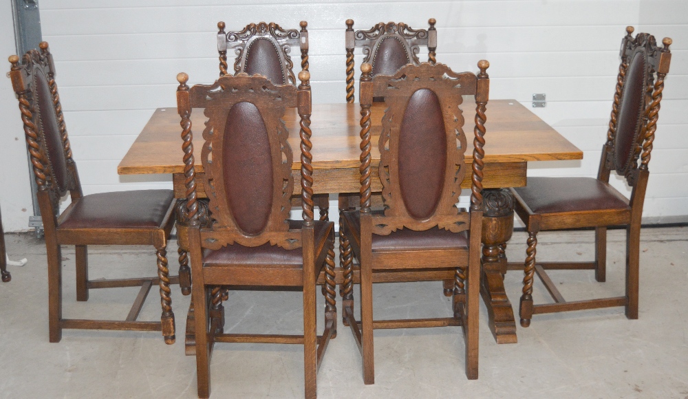 An early 20th century oak dining table on baluster supports to stepped base and cross stretcher,