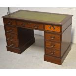 A reproduction nine-drawer mahogany green leather inset pedestal desk, approx width 122cm.