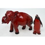 A Royal Doulton flambé elephant, approx length 23cm and a Royal Doulton flambé penguin,